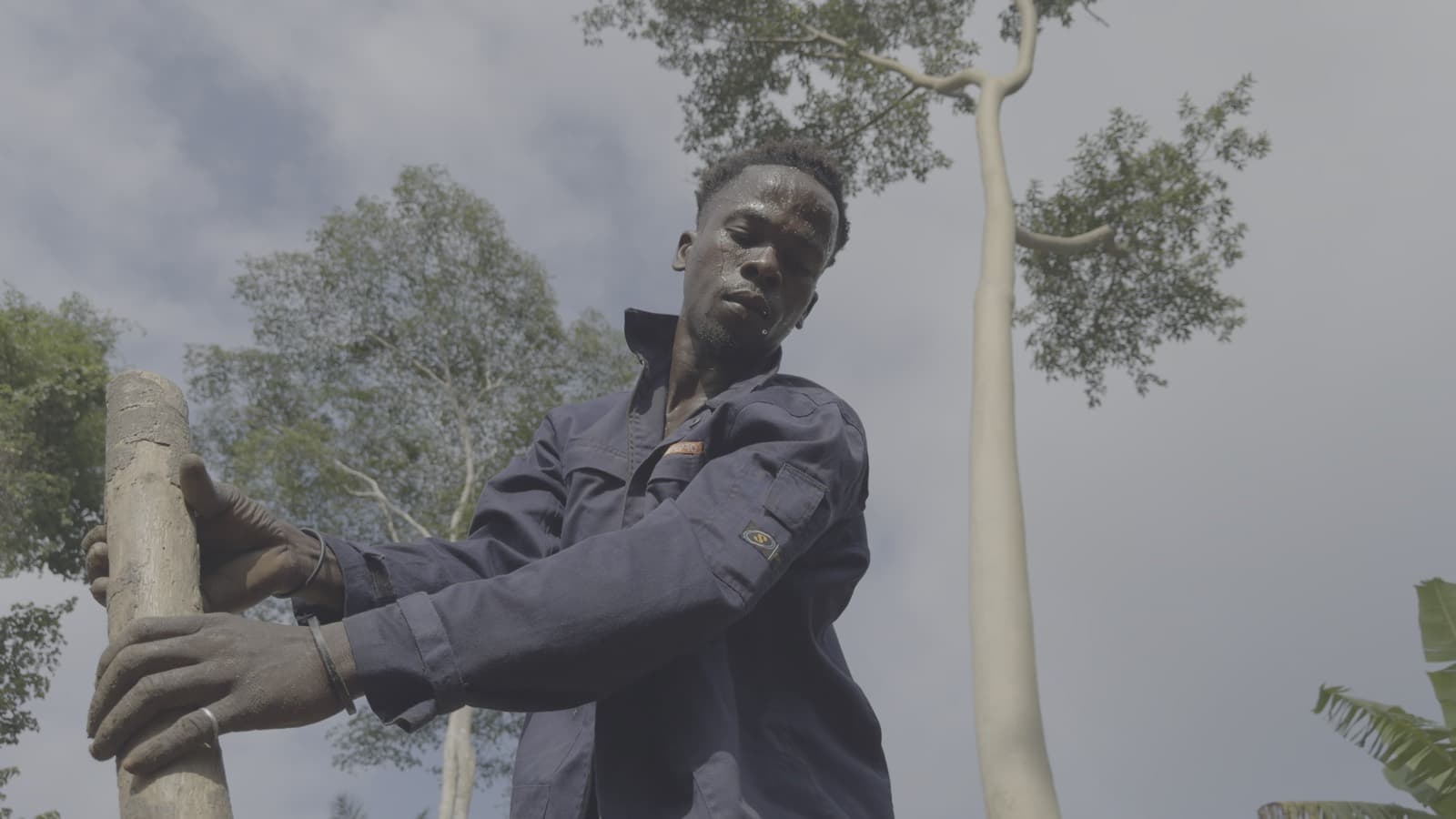 Man holding a felled tree trunk