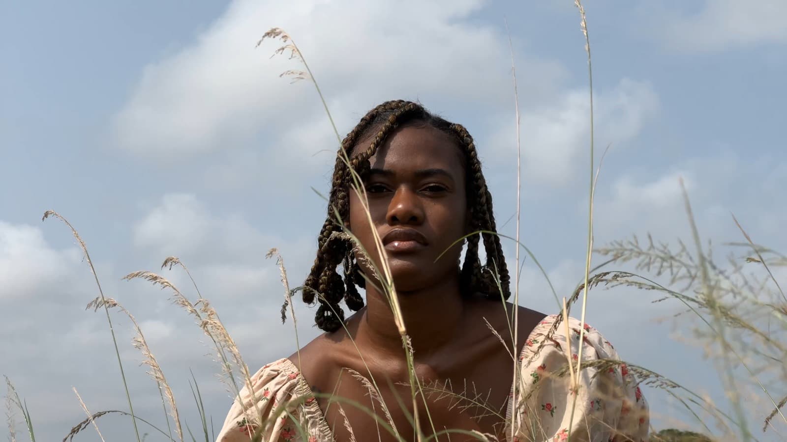 Portrait in tall grass against the sky